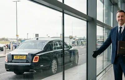 Professional Rolls-Royce Phantom chauffeur waiting at the airport arrivals.